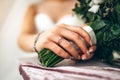 Closeup photo of brideÃ¢â¬â¢s hand with ring and flowers